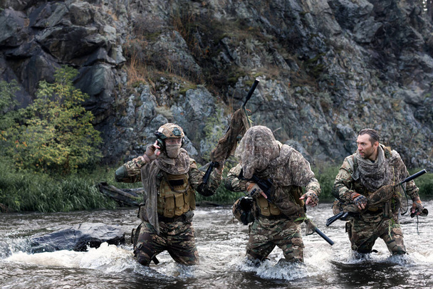 Τρεις στρατιώτες διέσχισαν ένα ποτάμι κατά τη διάρκεια μιας ειδικής επιχείρησης. Αντίληψη των σύγχρονων πολεμικών αποστολών και προκλήσεις πίσω από τις γραμμές του εχθρού. COLLAGE - ένα μοντέλο σε τρεις στάσεις. - Φωτογραφία, εικόνα