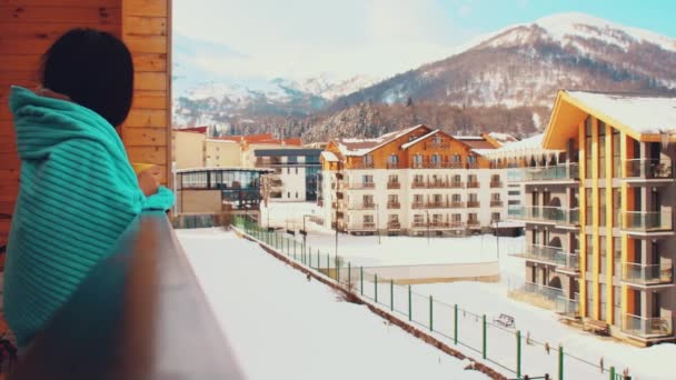 Бакуриани, Грузия - 5 марта 2022 года: женщина-туристка кавказского происхождения утром пьет кофе на балконе в доме отдыха на горнолыжном курорте Бакуриани в Грузии. - Кадры, видео