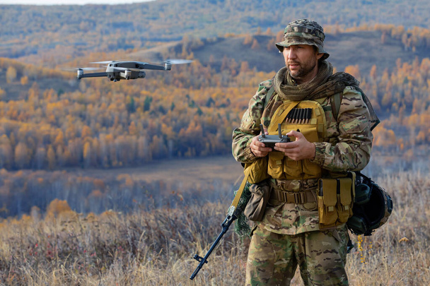 An artillery spotter or military observer launches a drone into the sky for reconnaissance in enemy territory. Modern methods of warfare. - Photo, Image