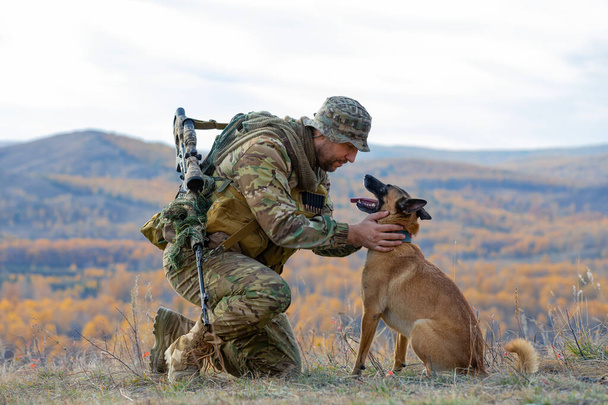 Soldier with a best friend - dog. Infantryman looking into the eyes of his faithful friend - a dog of the Malinois breed. Outdoor photo. - Foto, Imagem
