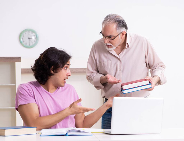 der alte Vater hilft seinem Sohn bei der Prüfungsvorbereitung - Foto, Bild