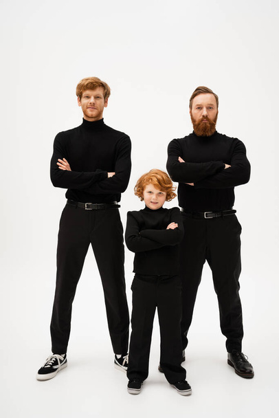 full length of bearded man with redhead son and smiling grandson posing with crossed arms on light grey background - Foto, Imagem