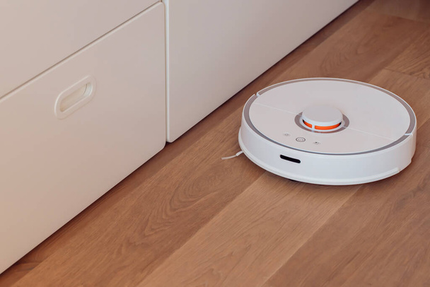 Robot vacuum cleaner performs automatic cleaning of the apartment in smart home - Photo, Image