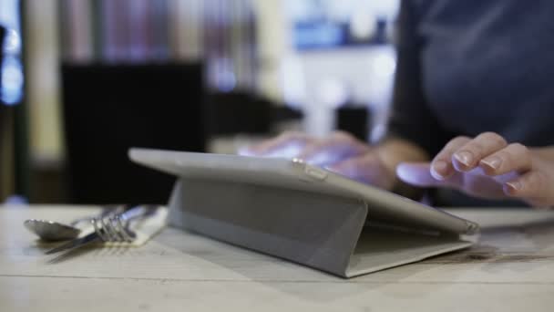 Nainen kahvilassa käyttäen tablet PC lähettää viestin
 - Materiaali, video