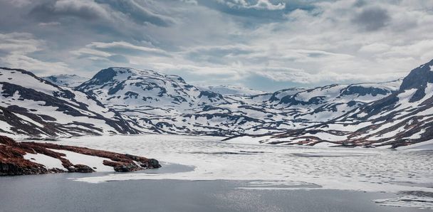 Landscape of Hardangervidda with mountains, snow, ice and lake in Norway during spring - Foto, Imagem