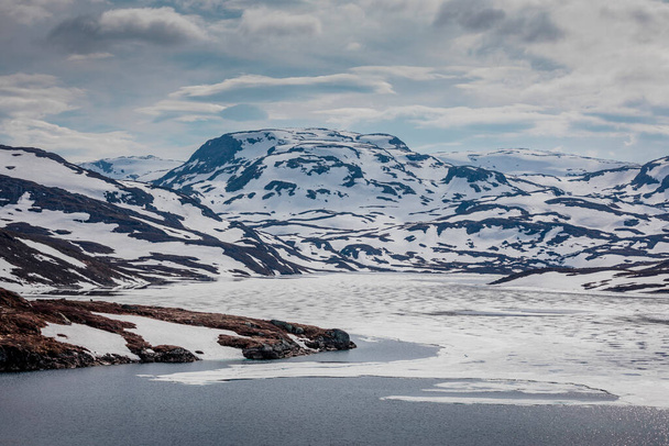 Пейзаж Хардангервидды с горами, снегом, льдом и озером в Норвегии весной - Фото, изображение
