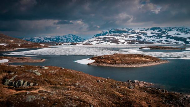 Снежный ландшафт национального парка Хардангервидда с горами и ледяными озерами в Норвегии, сверху - Фото, изображение