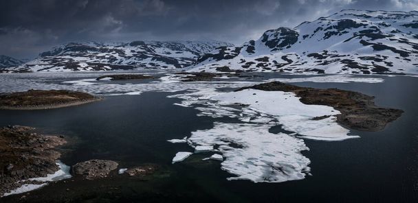 Snowy landscape of Hardangervidda national park with mountains and icy lakes in Norway, from above - Fotó, kép