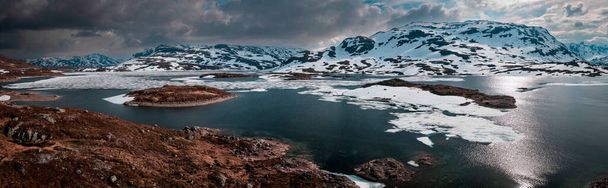 Snowy landscape of Hardangervidda national park with mountains and icy lakes in Norway, from above - Foto, imagen