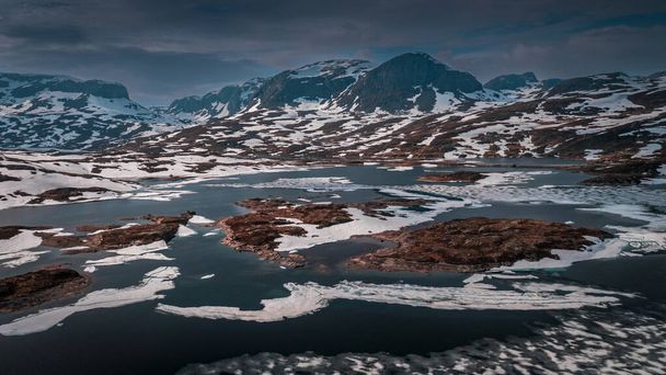 Snowy landscape of Hardangervidda national park with mountains and icy lakes in Norway, from above - Fotó, kép