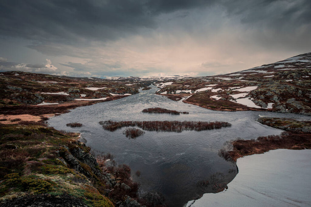 River with snow in the landscape of Hardangervidda National Park in Norway - Foto, afbeelding