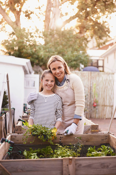 Свежий это единственный выход. Портрет матери и дочери, вместе занимающихся садоводством на заднем дворе - Фото, изображение