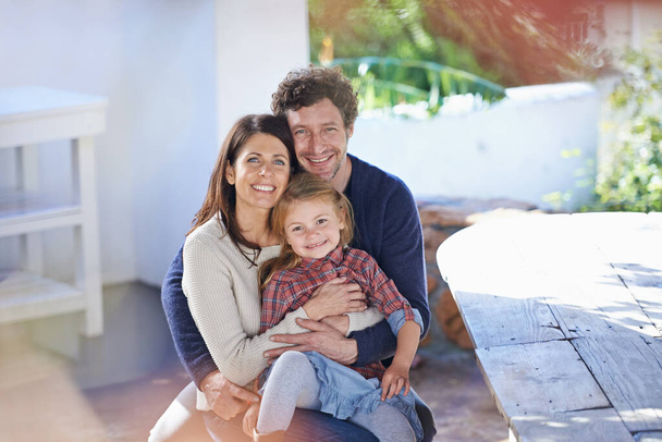 Moments to cherish. Portrait of a happy family of three smiling while relaxing together - Foto, immagini