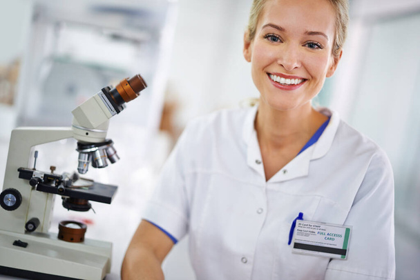 The answers are all in the details. Portrait of a smiling female researcher sitting at a laboratory - Foto, Imagem