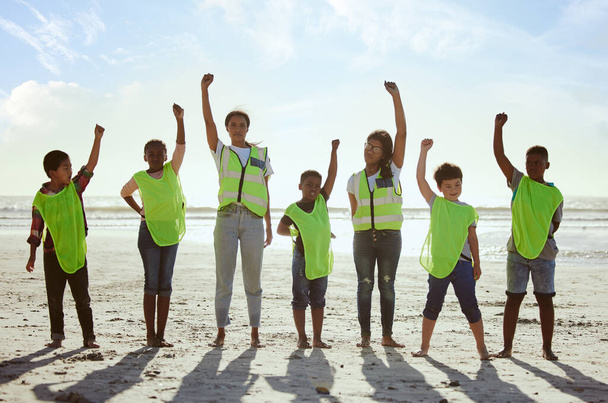 Children, volunteer and beach clean up with friends standing on the sand together for eco friendly conservation. Team, nature and cleaning with kids cleaning the environment for a green earth. - Photo, Image