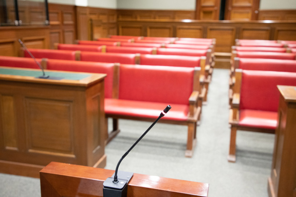 tanúk mikrofonja az igazságszolgáltatás tárgyalótermében az íróasztallal, a védelem és a vád hivatalaival - Fotó, kép