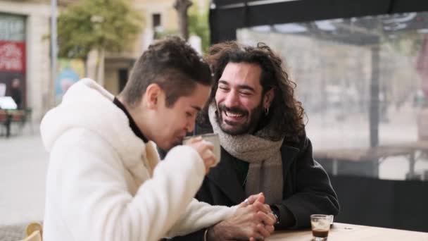 Slow motion video of a happy gay couple enjoying together a coffee in a terrace of a cafeteria - Filmagem, Vídeo