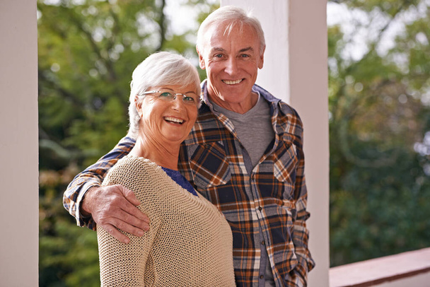 彼女は私の宝だ。自宅のバルコニーに立っている幸せな高齢者のカップルの肖像画 - 写真・画像