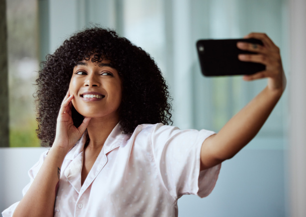 Selfie, beauty and skincare with a black woman taking a picture in the bathroom of her home in the morning. Facial, phone and influencer with an attractive female posing for a social media photograph. - Foto, immagini