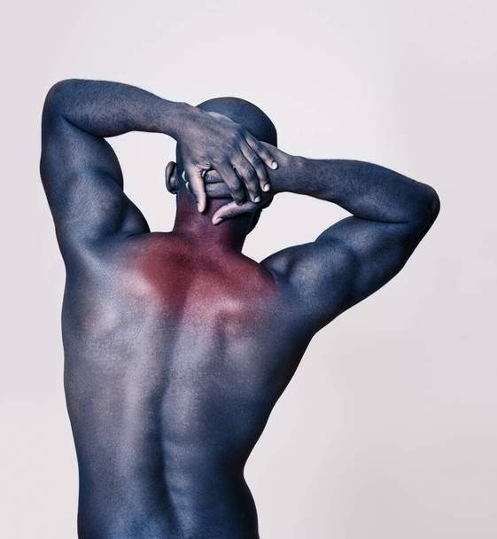 Όλοι οι μύες και ο άνθρωπος. Στιγμιότυπο ενός μυώδους Αφροαμερικανού που τεντώνεται με ευαισθησία στη θερμότητα. - Φωτογραφία, εικόνα