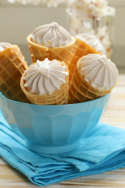 Cône de gaufrette sucrée remplie de crème vanille
 - Photo, image