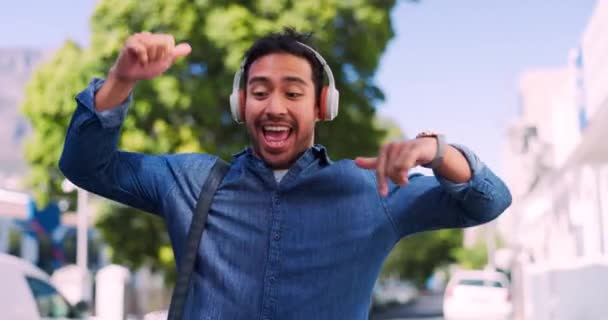 Asian man dancing, headphones and celebration with music, outdoor and casual. Male, guy and headset for streaming, relax and excited for online song, happy or success with dance, trendy and in street. - Footage, Video