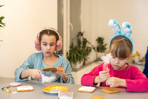 two cute sisters make and decorate cookies. - Photo, Image