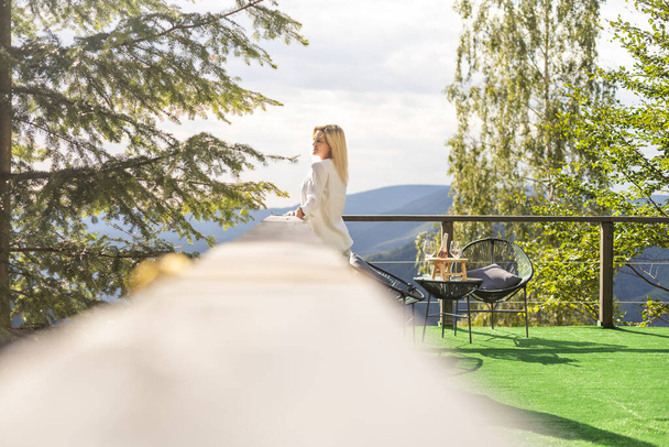 Young beautiful woman on the terrace in the mountains. - Photo, Image