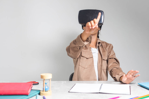 Little girl using VR glasses at home for learning. Modern education science concept. - Foto, imagen