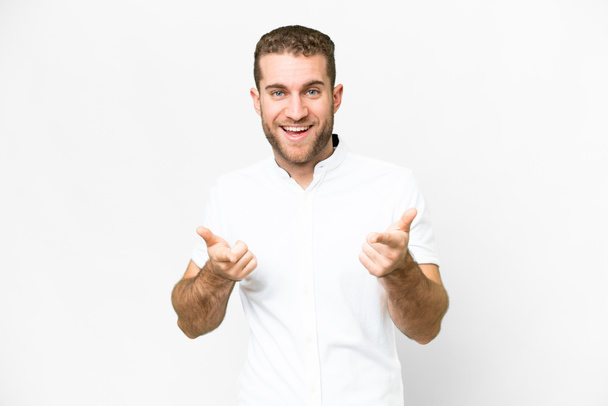 Young handsome blonde man over isolated white background pointing to the front and smiling - Foto, imagen