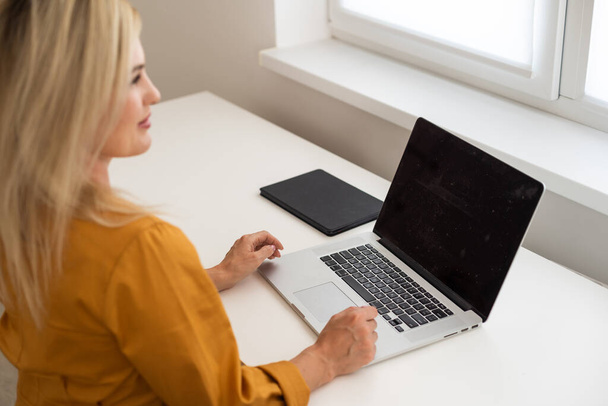 Shot of a middle aged woman using a laptop at home. Businesswoman working from home - Foto, Imagem