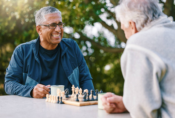 夏の間屋外で結合しながら、ボードゲームをプレイする先輩の友人とチェス、自然と退職。精神的な挑戦について考える大人の男と友人と公園、戦略とゲーム. - 写真・画像