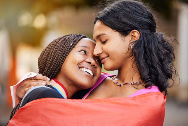 Love, hug and happy lesbian couple at a freedom, equality or LGBTQ festival, event or parade. Happiness, smile and gen z interracial gay women embracing, hugging and bonding together in the city - Foto, Imagen
