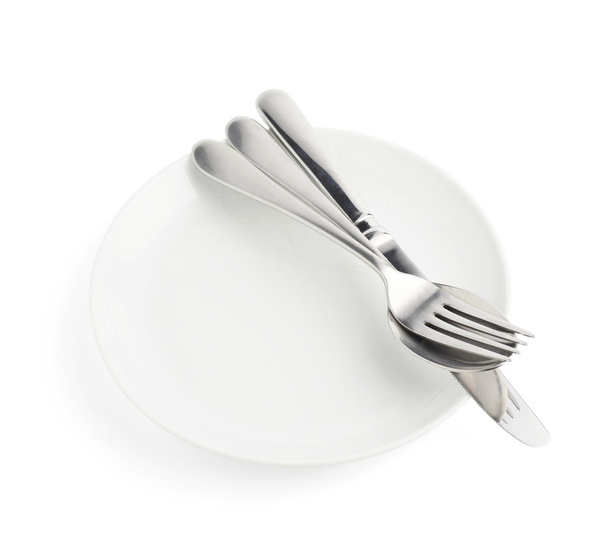 Spoon, fork and knife over the white plate - Photo, image