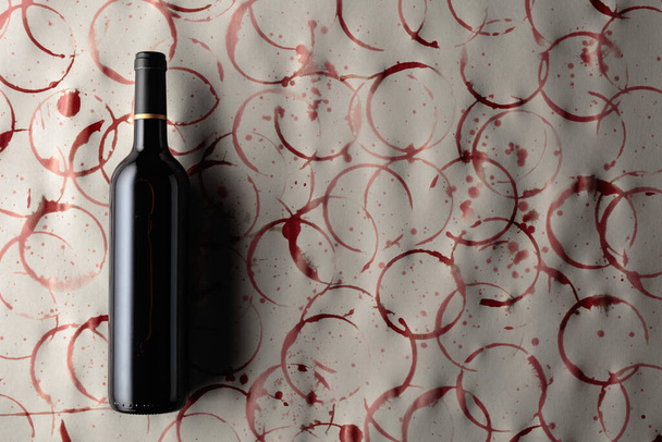 Bottiglia di vino rosso su fondo con macchie di vino. Copia spazio. - Foto, immagini