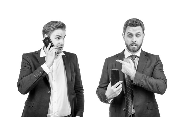 κατάπληκτος επιχειρηματίες του άντρα δείχνοντας δάχτυλο στον άνθρωπο μιλώντας στο τηλέφωνο απομονώνονται σε λευκό, σε απευθείας σύνδεση επιχείρηση. - Φωτογραφία, εικόνα