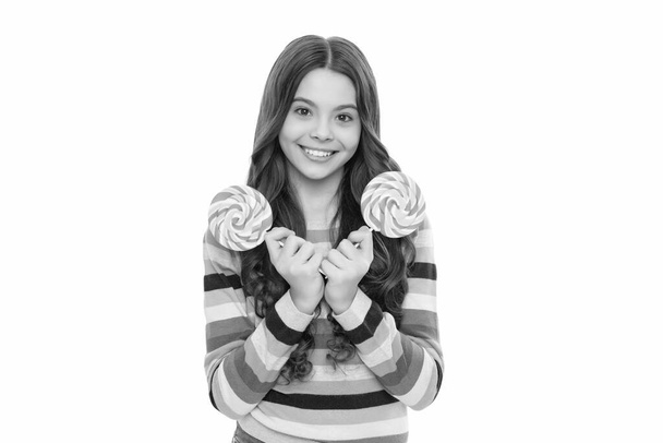 szczęśliwy nastolatek dziewczyna w kolorowy sweter z lizakiem cukierki na kij izolowane na białym tle, karmel sklep. - Zdjęcie, obraz