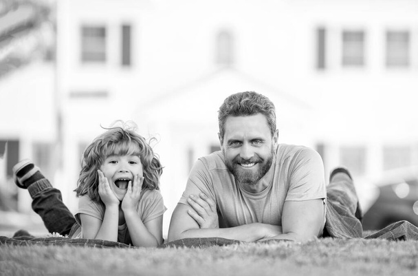 childhood and parenthood. parent relax with little child boy on grass. dad with kid on summer day. parenting and fatherhood. fathers day. happy father and son having fun in park. family value. - Foto, Bild