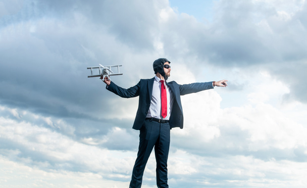 businessman in suit and pilot hat launch plane toy on sky background. freedom. - Zdjęcie, obraz
