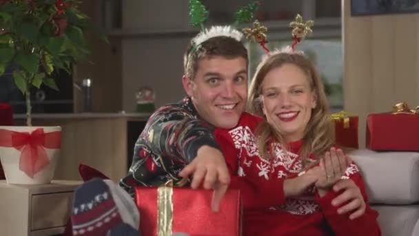 PORTRAIT: Twosome σε εορταστική διάθεση τραγούδι και χορό, ενώ χαλαρώνει στον καναπέ. Χαρούμενο ζευγάρι σε χριστουγεννιάτικα πουλόβερ γιορτάζει τις διακοπές και να απολαύσετε χαλαρωτικές εορταστικές στιγμές σε άνετο καναπέ. - Πλάνα, βίντεο