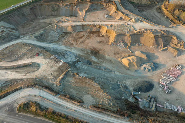 Vue aérienne du site minier à ciel ouvert de matériaux calcaires pour l'industrie de la construction avec pelles et camions à benne basculante. - Photo, image