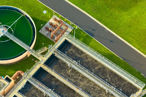 Aerial view of modern water cleaning facility at urban wastewater treatment plant. Purification process of removing undesirable chemicals, suspended solids and gases from contaminated liquid. - Photo, image