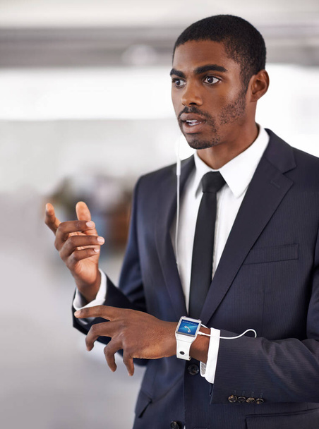 Well equipped for modern business. Cropped view of a young businessman wearing a smartwatch with a digital interface - All screen content is designed by us and not copyrighted by others - Photo, Image