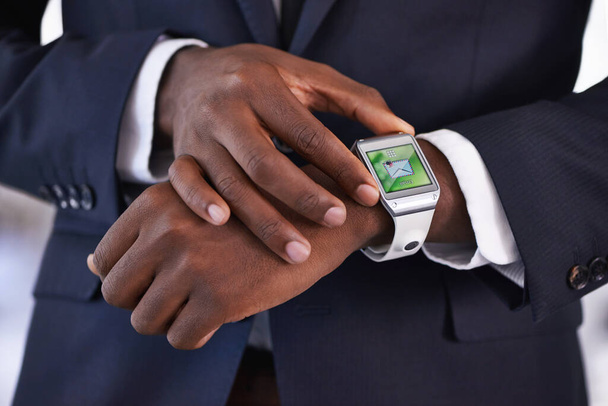 Digital technology just gets smarter and smarter. Cropped view of a young businessman wearing a smartwatch - All screen content is designed by us and not copyrighted by others - Photo, Image