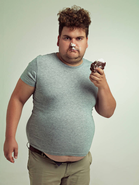 What This is how you eat cake. an overweight man messily eating a slice of cake - Foto, Imagen