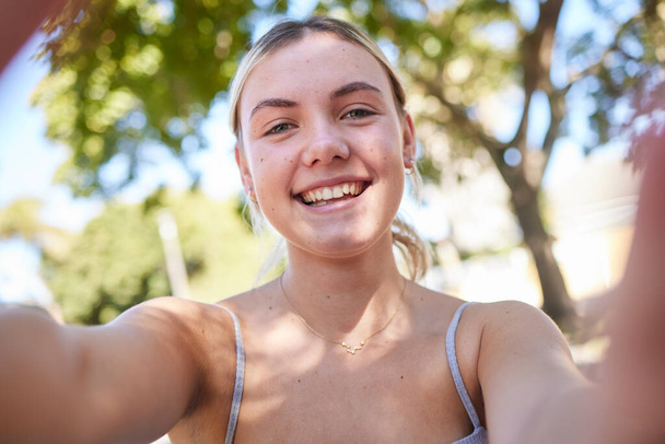 Selfie, park and portrait of woman in summer enjoying holiday, vacation and weekend in nature. Freedom, happy lifestyle and face of girl taking photo outdoors for relaxing, adventure and carefree day. - Fotó, kép