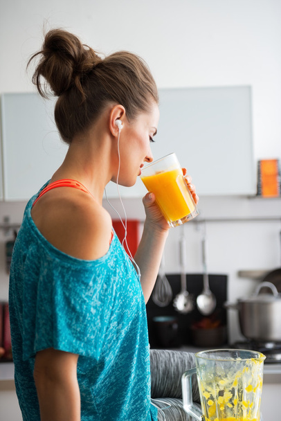 Fitness young woman drinking pumpkin smoothie in kitchen - Zdjęcie, obraz