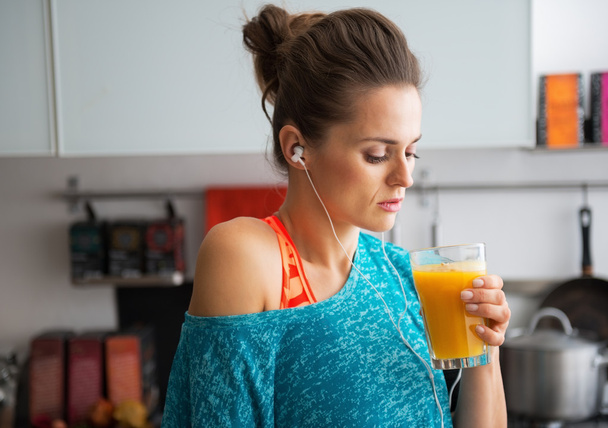 Portret van fitness jonge vrouw drinken pompoen smoothie in kit - Foto, afbeelding