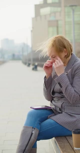 40 years old woman receives the message and is insanely upset. She lowers her head and wraps her arms around it. Vertical video. - Imágenes, Vídeo