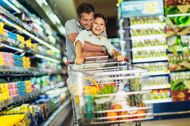 Vater und Sohn beim Einkaufen im Supermarkt - Foto, Bild